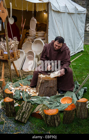 Un homme en costume médiéval faisant un bol en bois à la main à l'Ludlow Castle Noël Nourriture et foire artisanale. Le Shropshire Banque D'Images