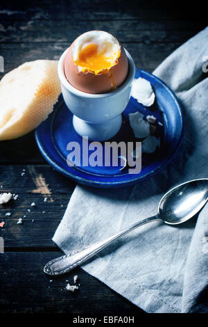 Le petit-déjeuner avec des oeufs à la coque, servi avec du pain sur la table en bois. Banque D'Images