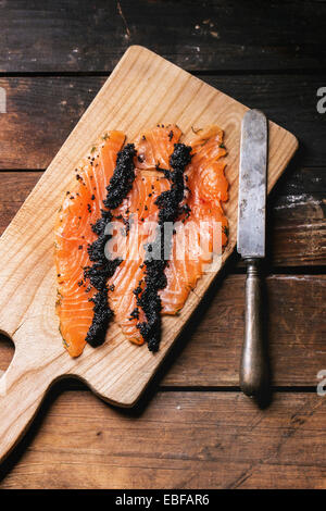 Morceaux de poisson sur une planche à découper, épices sur une rustique en  bois vintage avec un couteau de cuisine Photo Stock - Alamy