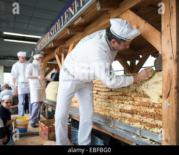 Dresde, Allemagne. 30Th Nov, 2014. Les boulangers de Dresde couvrir le Stollen géant avec du beurre dans la Neue Messe à Stuttgart, Allemagne, 30 novembre 2014. Le gâteau géant est composé de 40 morceaux stollen. Le Stollen géant avec coupe pour le Stollen fest le 06 décembre 2014. Photo : OLIVER KILLIG/dpa/Alamy Live News Banque D'Images