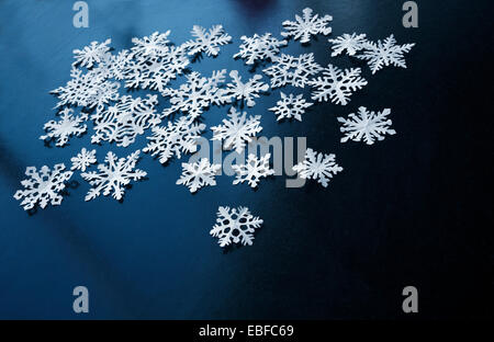 Flocons de papier blanc sur fond bleu foncé Banque D'Images