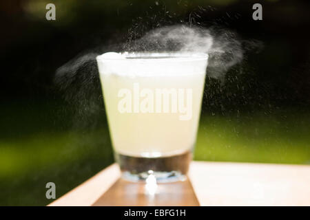 Un comprimé effervescent se dissout dans un verre d'eau sur Banque D'Images
