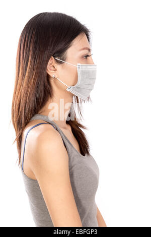 Chinese woman wearing surgical mask avec fond blanc, portrait Banque D'Images