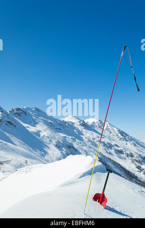 Pelle et sonde rouge graduée pour la sécurité avalanche neige fraîche de poudre. La saison d'hiver dans les Alpes italiennes. Banque D'Images