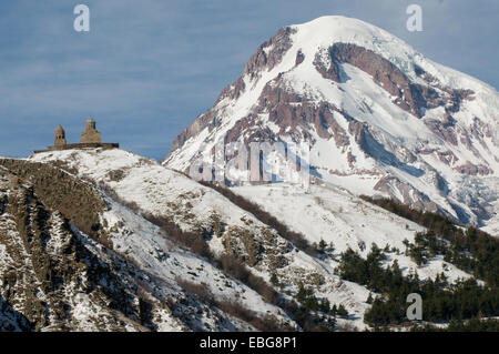 Ce sont des montagnes du Grand Caucase en hiver. L'église de trinité Gergeti est situé au bas du Mont Kazbek. Banque D'Images