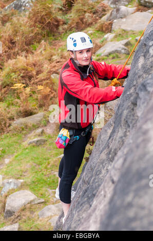 Les jeunes adolescentes de l'escalade sur le bord noir-argenté dans le Peak District du Derbyshire Banque D'Images