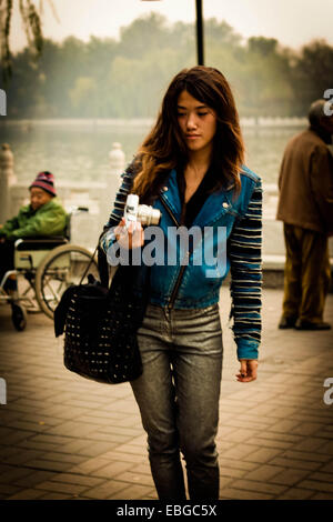 Jeune femme tenant une caméra dans Houhai, Beijing, Chine Banque D'Images