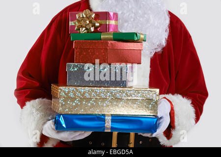 Close Up of Santa Claus Holding Pile of Gift Wrapped Presents Banque D'Images