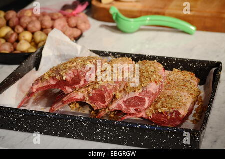 Plateau de cuisson avec des côtes d'agneau marinées au prêt pour four Banque D'Images