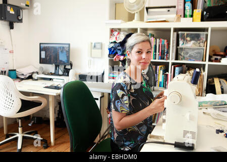 Designer travaillant dans machine à coudre dans studio Banque D'Images