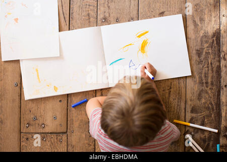 Jeune garçon dessin sur papier, high angle Banque D'Images