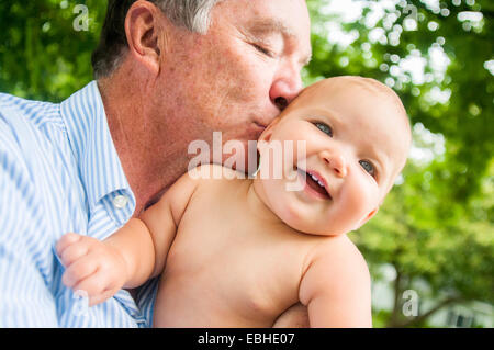 Portrait de grand-père embrassant bébé fille sur la joue Banque D'Images