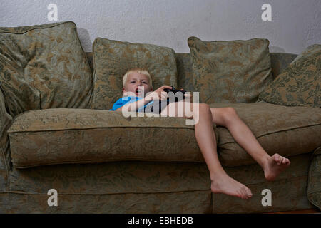 Boy playing video game in living room Banque D'Images