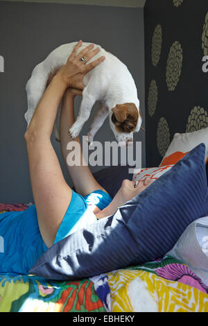 Woman holding up dog Banque D'Images