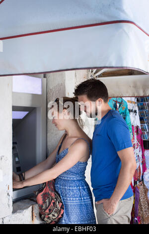 Jeune couple en utilisant street cash machine, Milna, Brac, Croatie Banque D'Images