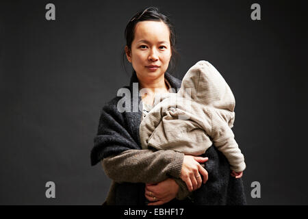 Studio portrait of mid adult woman holding baby son
