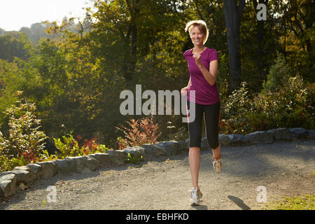 Mid adult woman running in park Banque D'Images