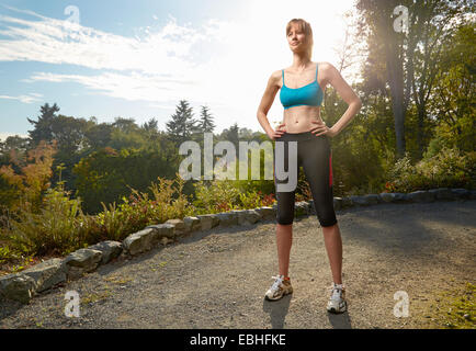 Portrait of female runner avec les mains sur les hanches dans park Banque D'Images