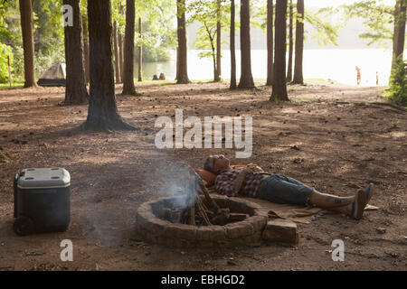 L'homme couché à côté de feu de forêt, Arkansas, États-Unis Banque D'Images