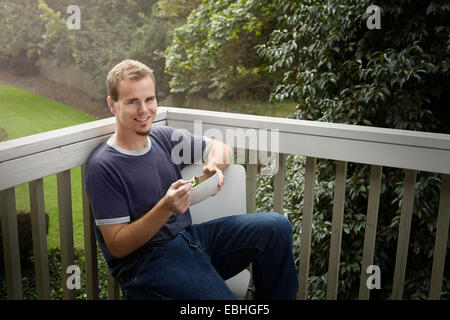 Jeune homme ayant balcon sur salade Banque D'Images