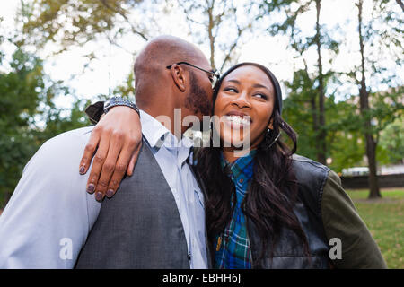 Man kissing woman's cheek in park Banque D'Images