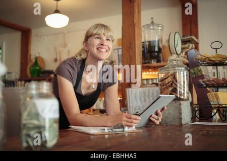 Femme shop assistant with digital tablet in country store Banque D'Images