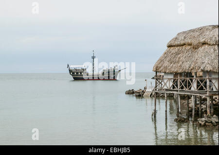 Approche d'un bateau de pirates avec dock guindé, et toit de chaume patio salle à manger au-dessus de l'eau, de la baie de Campeche, Campeche, Mexique. Banque D'Images