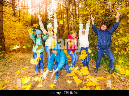 Heureux les enfants qui jouent avec les feuilles de vol Banque D'Images