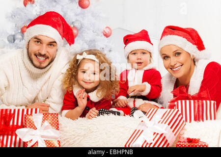 Famille de quatre personnes avec des présents et l'arbre de Noël Banque D'Images