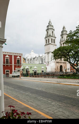 Campeche centre-ville, notamment la cathédrale de Campeche, coloré traditionnel l'architecture coloniale espagnole, vu de sous une arche sur le côté rue, Mexique Banque D'Images