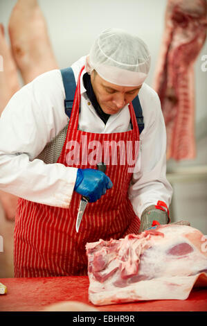 Les bouchers au travail dans une usine de transformation de la viande Banque D'Images