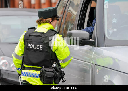 Belfast, Irlande du Nord. 01 déc 2014 - officier PSNI vérifie un permis de conduire temporaire à un poste de contrôle des véhicules. Elle vient après que le CAC sera Kerr prévient que les républicains dissidents sont l'intention de lancer une campagne de bombardements ou tué au cours de la période de Noël. Crédit : Stephen Barnes/Alamy Live News Banque D'Images