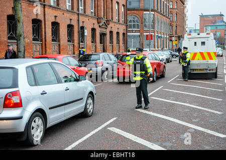 Belfast, Irlande du Nord. 01 déc 2014 - officier PSNI vagues sur le trafic à un point de contrôle temporaire de véhicule. Elle vient après que le CAC sera Kerr prévient que les républicains dissidents sont l'intention de lancer une campagne de bombardements ou tué au cours de la période de Noël. Crédit : Stephen Barnes/Alamy Live News Banque D'Images