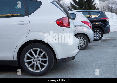 Voitures garées au parking dans la neige. Maison de vacances d'hiver. Banque D'Images