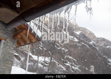 Pende de glaçons sur le toit de cabine. Scène de montagne enneigée. L'hiver dans les Alpes. Valle d'Aoste, Italie. Banque D'Images