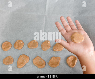 Jeune garçon de 6 cuire les cookies que sa main est visible Banque D'Images