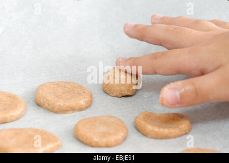 Jeune garçon de 6 cuire les cookies que sa main est visible Banque D'Images