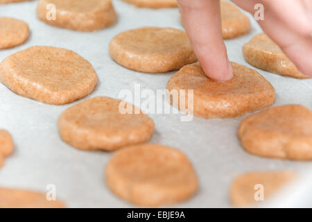 Jeune garçon de 6 cuire les cookies que sa main est visible Banque D'Images