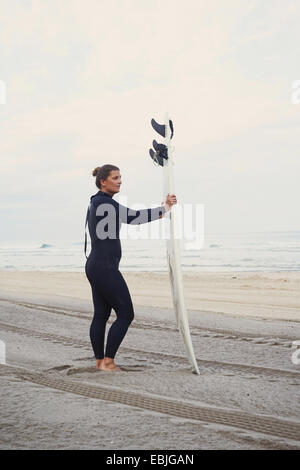 Surfer avec surfboard on beach, Lacanau, France Banque D'Images