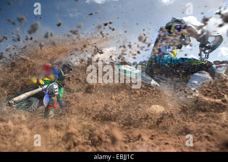 Deux jeunes hommes dans la boue des courses de motocross riders Banque D'Images