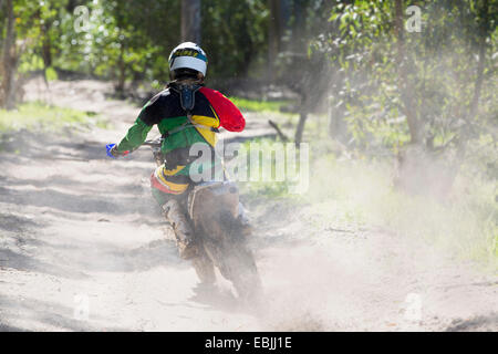 Vue arrière du jeune homme motocross rider course sur piste en forêt Banque D'Images