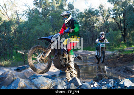 Deux jeunes coureurs de motocross racing mâle grâce à forest river Banque D'Images