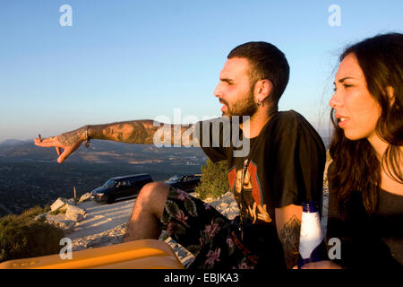 Jeune couple pointant et regardant la mer, Marseille, France Banque D'Images