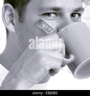 Jeune homme de boire une tasse de café Banque D'Images