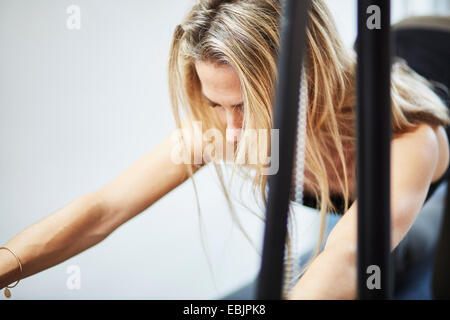 Close up of young woman laying pilates sur table trapeze pilates en salle de sport Banque D'Images