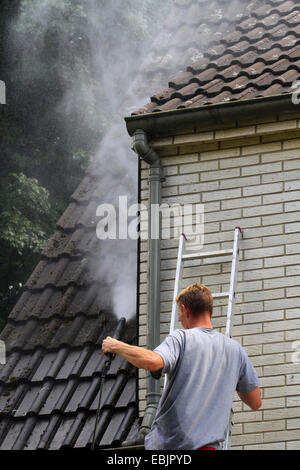 Le nettoyage de la toiture et façade d'une maison à pignon avec un blaster de l'eau à haute pression, l'Allemagne, l'Nordrhein Westfalen, Ruhr, Essen Banque D'Images