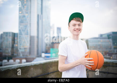 Teenage boy holding basketball Banque D'Images