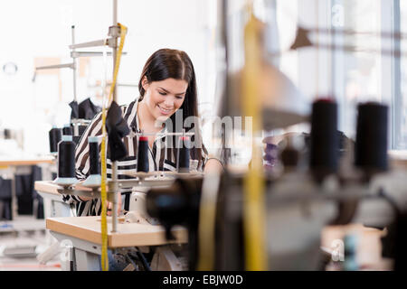 Jeune femme couturière à l'aide de la machine à coudre à l'atelier Banque D'Images