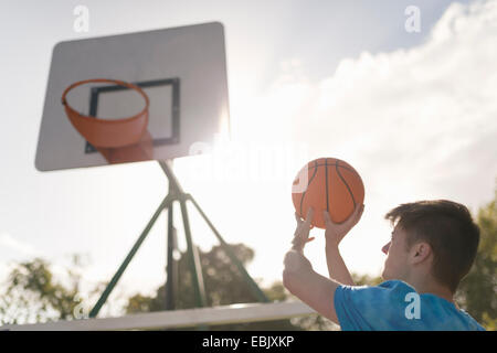 Jeune homme visant à jeter en basket-ball Basket-ball Banque D'Images