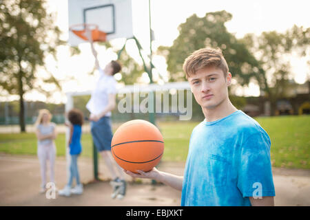 Portrait de jeune homme basket-ball player holding basketball Banque D'Images
